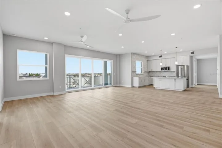 Open great room and kitchen with wood-look floors and water views
