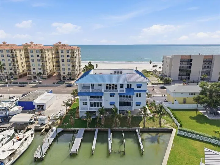 Aerial photo of the building and its private boat slips on the harbor, with the Gulf beyond